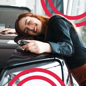 Mulher abraçando o seu carro sorrindo