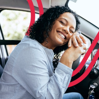 Mulher sorrindo no volante do carro