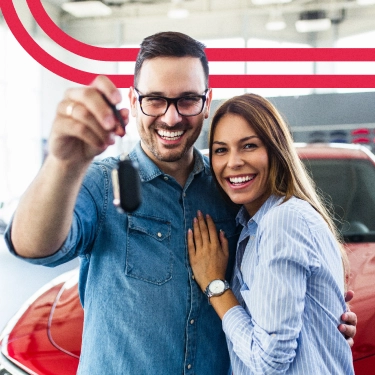 Casal feliz com chave de carro.