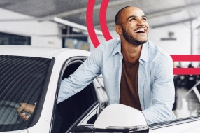 Homem saindo de um carro sorrindo
