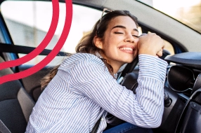 Mulher sorrindo apoiada no volante do carro