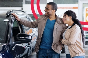 Casal observando um carro novo.