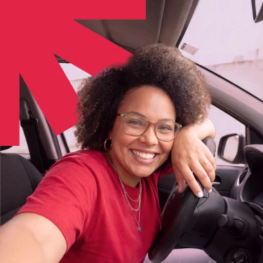 Pessoa usando o celular dentro de um carro vermelho, em banner da Webmotors