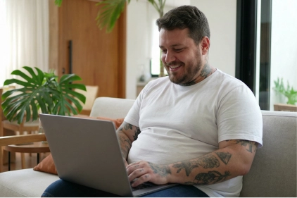 Homem usando laptop em casa.