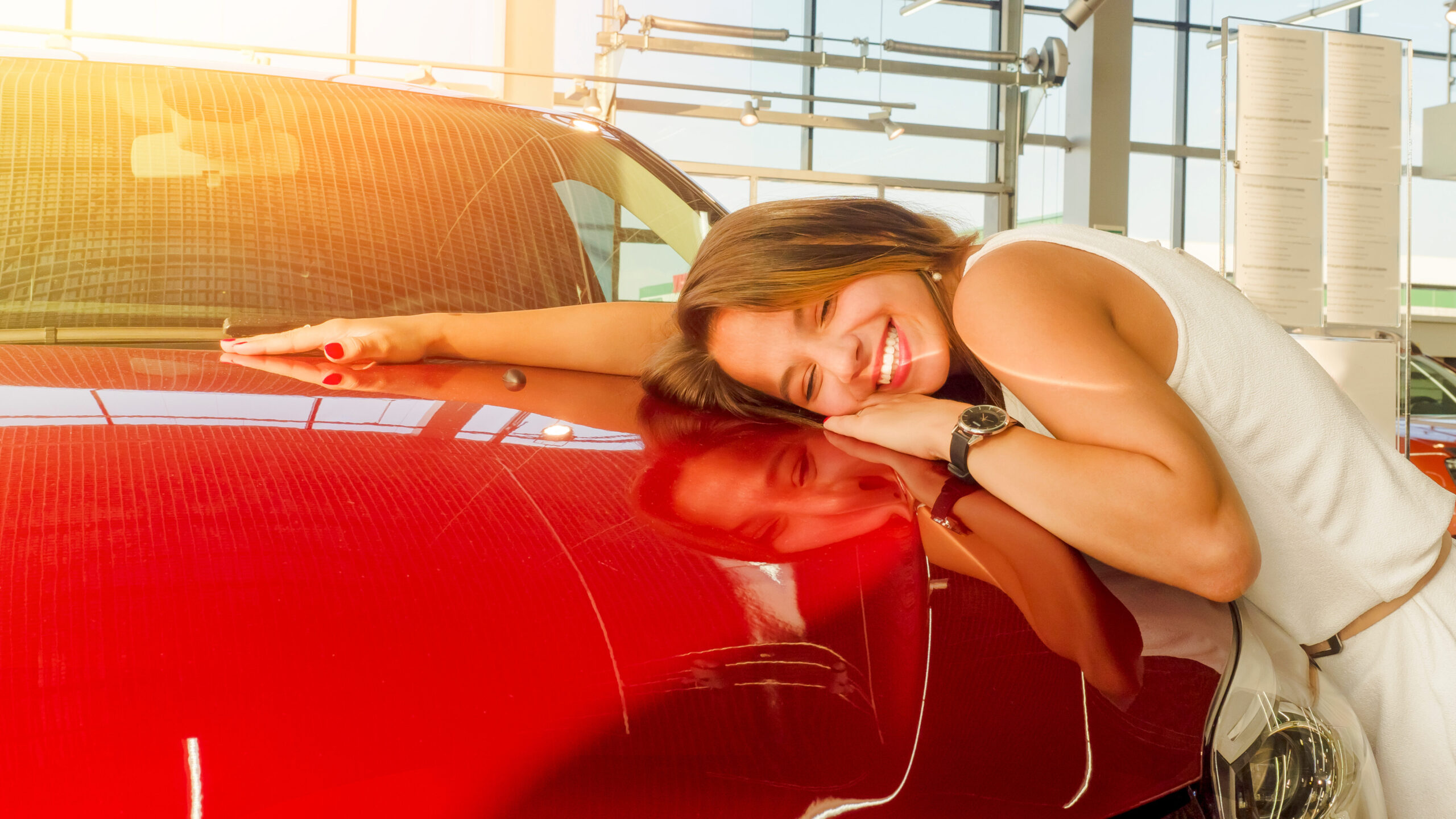 intenção de compraa Mulher sorrindo ao lado de carro